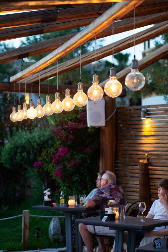 Outdoor pergola with hanging Edison bulbs at Zakanthi Restaurant at dusk, Kalamaki Zakynthos